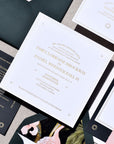 Collection of elegant wedding invitations with floral designs on a textured surface.