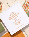 Wedding invitation card with orange text on a patterned background
