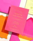 Colorful wedding invitation set with pink envelopes and cards on a white background