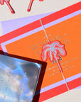Orange invitation card with palm tree design on a beige background