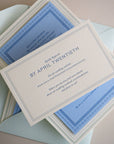 Wedding invitation card with blue and white design on a beige background