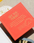 Red invitation card with 'See You There?' text on a textured surface