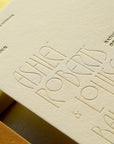 Invitation card with embossed text on beige paper