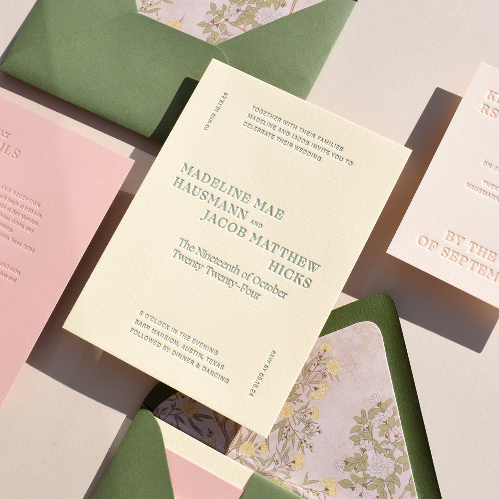 Wedding invitation card with floral envelope on a textured surface