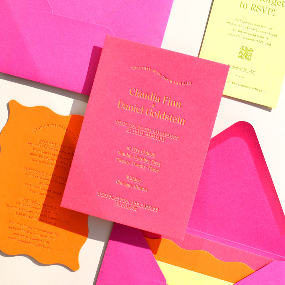 Colorful wedding invitation set with pink envelopes and cards on a white background
