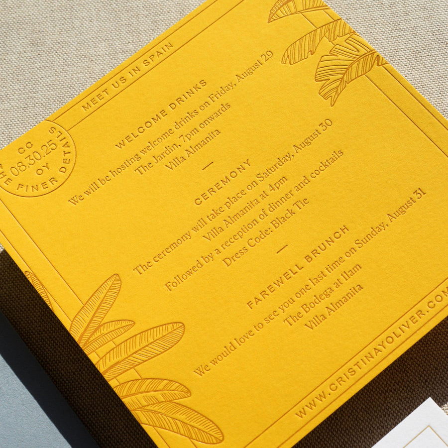 Yellow wedding invitation with engraved details on a textured surface